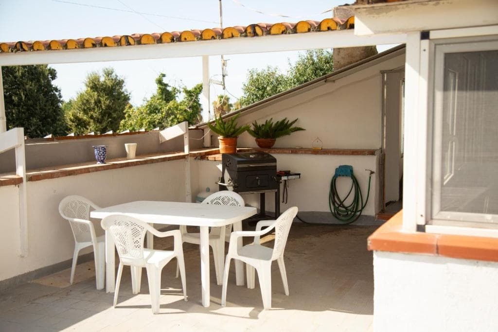 Sunny terrace with dining table and barbecue at Casa Petito